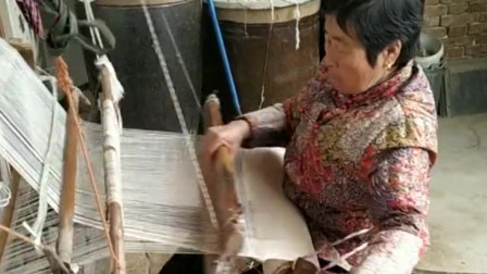 老奶奶脚踩的是老式织布机，手里拿的是梭子，现在还有多少人能叫出名字？