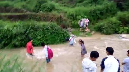 这是贵州省  铜仁松桃苗族自治县陆地村的学生，冒着生命过河去上学的路上，希望有关部门能重视一下这些学生，帮他们架一座桥，不然学生过河太危险了
